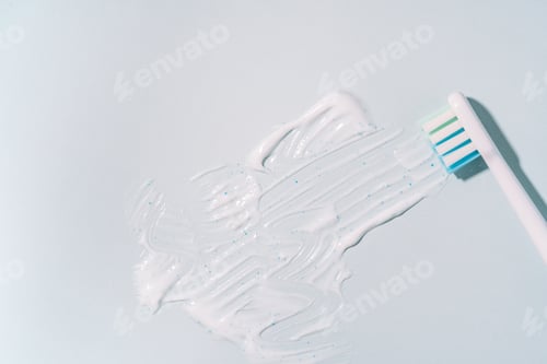 Preview: Smeared toothpaste with electric toothbrush over blue background