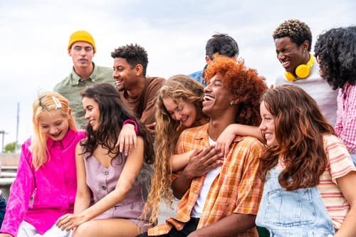 Preview: Happy playful multiethnic group of young friends bonding outdoors