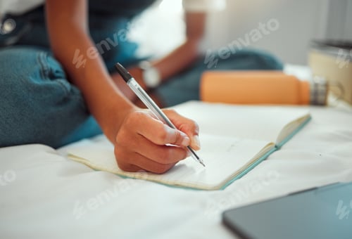 Preview: Notebook, bed and hands of student writing homework, research project or journal entry while in hom