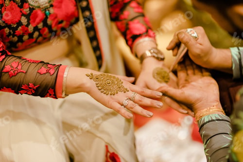 Preview: Woman having her hands tattooed with henna during a traditional Indian wedding