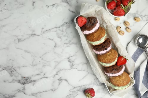 Preview: Different sweet delicious ice cream cookie sandwiches served on table, flat lay. Space for text