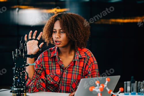 Preview: Portrait of a Black teenage student in a classroom learning about a robotic arm for her engineering