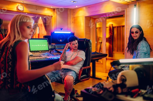 Preview: Band mates listening to the recording track after a session in a music studio.