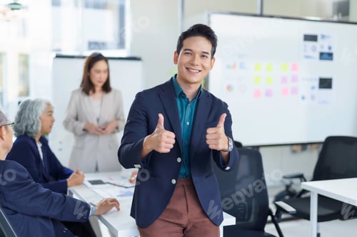 Preview: Asian businessman showing thumbs up during a meeting