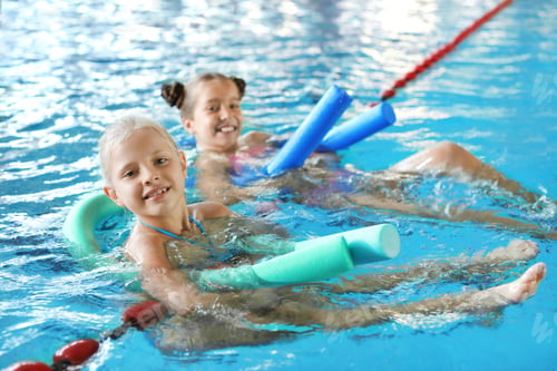 Preview: Little girls with swimming noodles in indoor pool