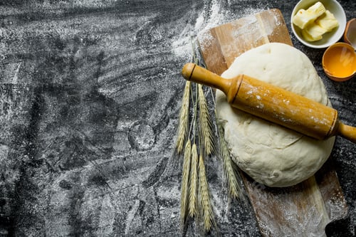 Preview: Dough on a cutting Board with eggs, butter and rolling pin.