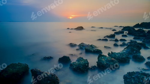 Preview: Long exposure stone in the sea at sunset time in Pattaya beach, Thailand.