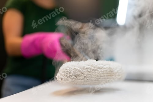 Preview: Woman cleaning kitchen furniture with a steam cleaner close up