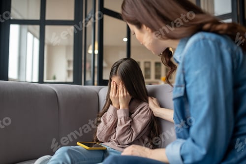 Preview: Crying daughter and comforting mom sitting on the couch.