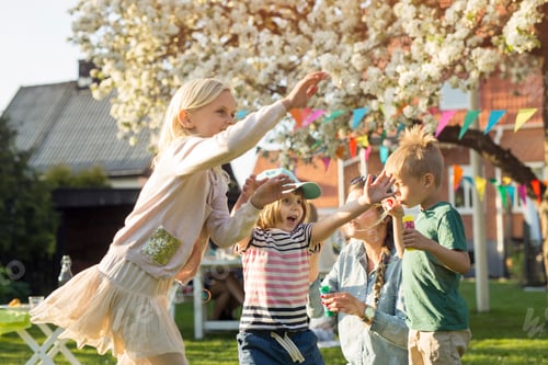 Preview: Children playing joyfully in a sunny backyard