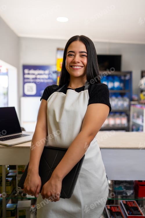 Preview: Woman entrepreneur wearing an apron, happily working in her retail store