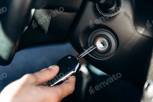 Preview: Selective focus of the male hand winds up the car ignition key