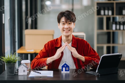 Preview: Asian male real estate agent is use hands to protect red roof for the concept