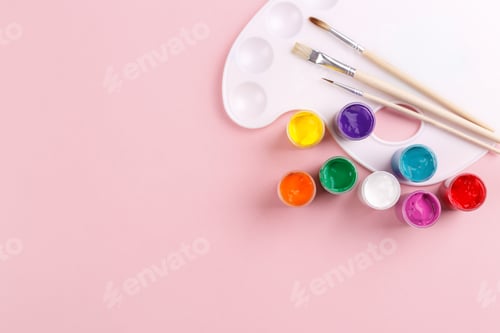 Colorful Paints and Brushes on Pink Background