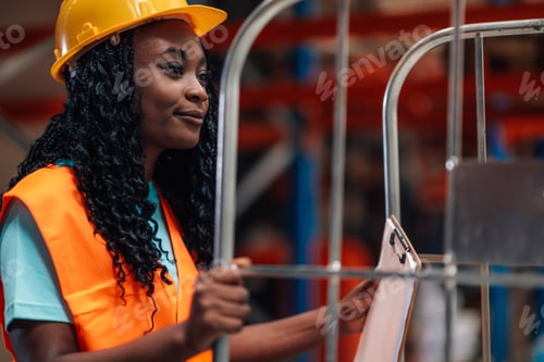 Preview: Female warehouse worker pushing trolley and checking inventory with clipboard