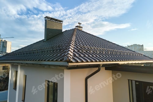 Preview: Closeup of house roof top covered with ceramic shingles with gutter pipes