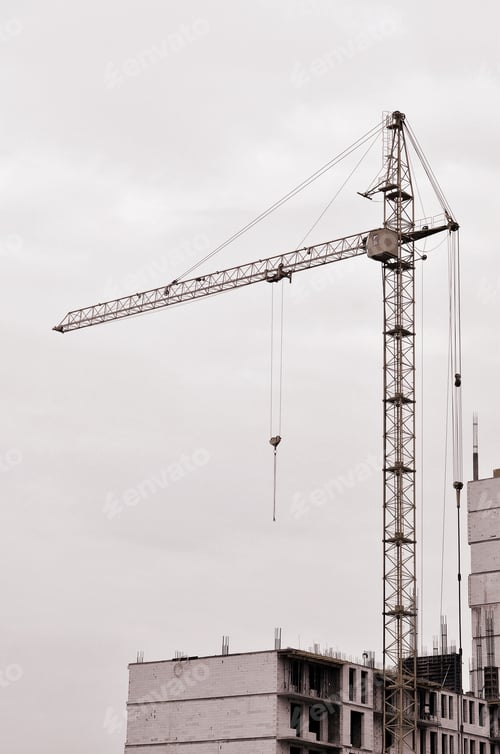 Preview: Working tall cranes inside place for with tall buildings under construction against a clear blue sky
