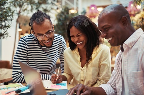 Preview: Businesspeople laughing together while working in an office lounge