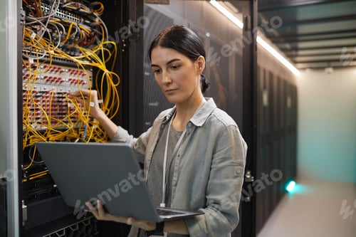 Preview: Female Network Technician Inspecting Servers in Data Center