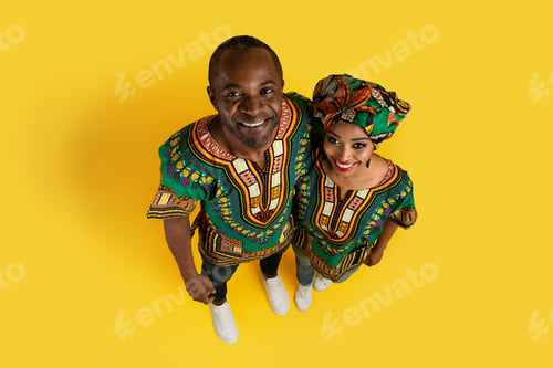 Preview: Top view of happy black couple embracing on yellow background