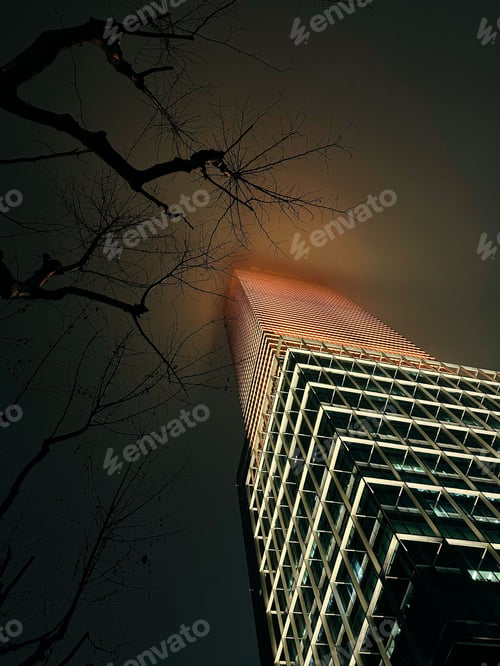 Preview: Low angle of an illuminated skyscraper at cloudy night in Shanghai, China