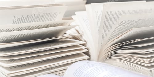 Preview: stack of books, close up. Open book on the table in library.