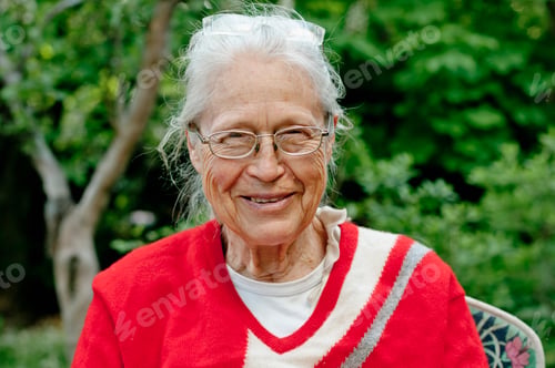 Preview: Elderly woman smiling gently in a lush garden