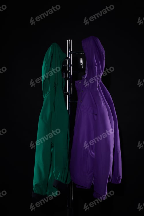 Preview: raincoats hanging on coat rack isolated on black