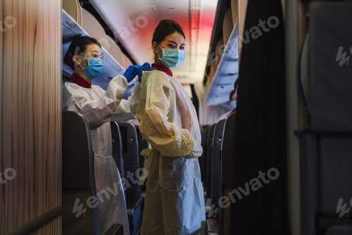 Vista previa: Two flight attendants with facemask and protective apron standin
