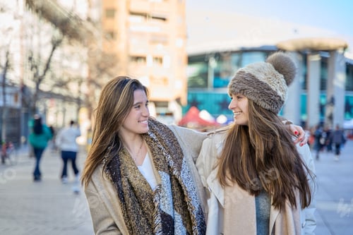 Preview: Forging Urban Friendships: Two Young Women Walking Through the City, Locking Eyes and Sharing Smile