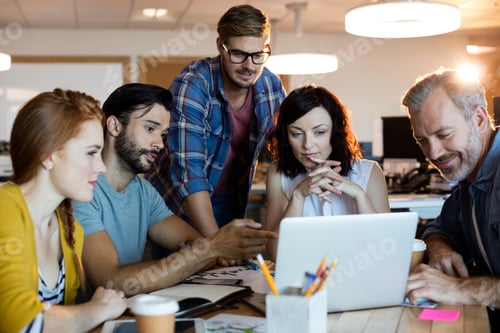 Preview: Smiling creative business team discussing over the laptop