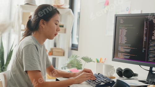 Preview: Side view of professional young Asia girl IT development programmer typing on keyboard.