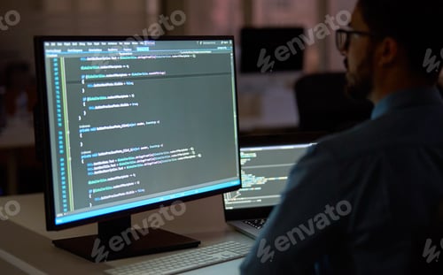 Preview: Busy businessman software developer working on pc computer in dark night office.