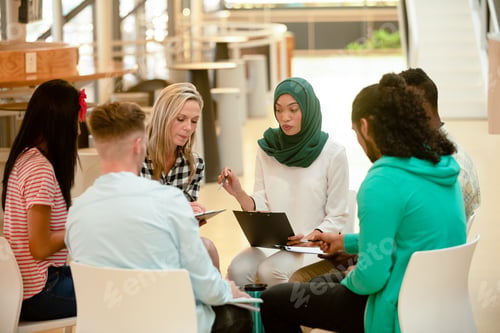 Preview: Diverse business people sitting together and having a group discussion