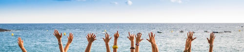Preview: group of female hands in panoramic style with ocean in background