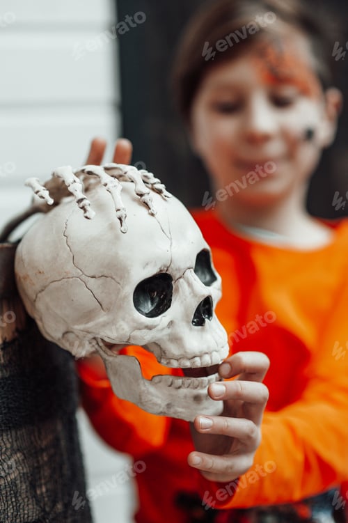 Preview: Portrait of candid authentic teen boy with face painted at decorated skeletons party Halloween