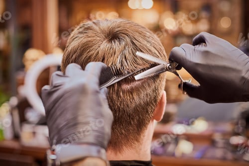 Preview: Male haircut in barbershop close up, client getting haircut by hairdresser with comb and scissors