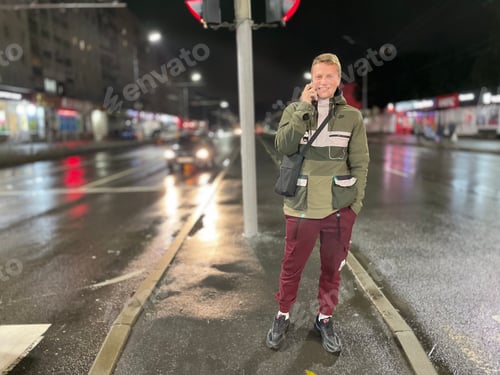 Preview: Man in Urban Setting Answering Phone at Night