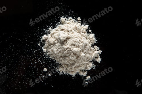 Preview: A pile of white powder extract of a medicinal plant for vegan cuisine isolated on a black background