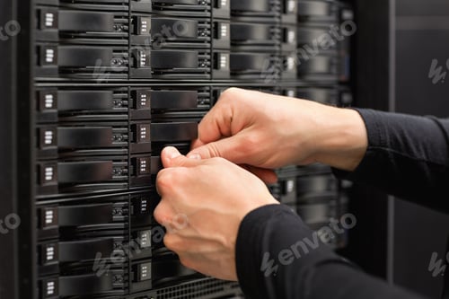 Preview: Male IT Engineer Adjusting Hard Drives In SAN At Datacenter
