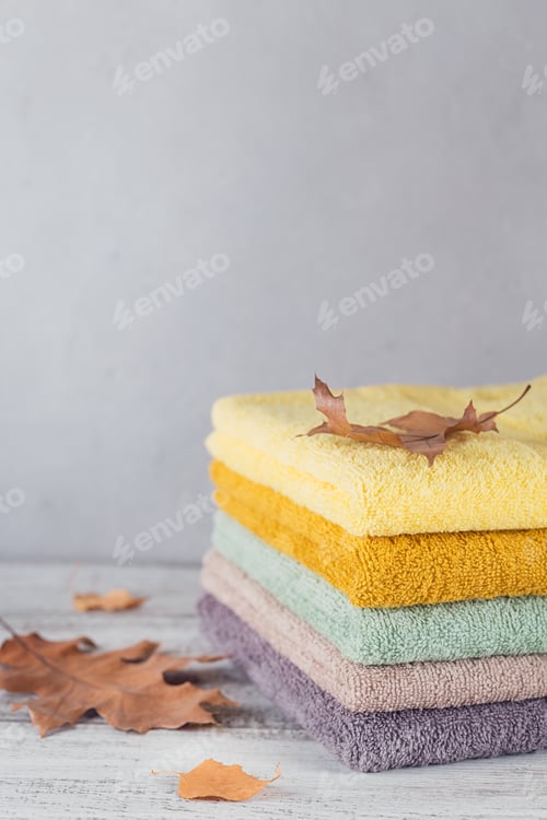 Preview: Stack of colorful bath towels on light background.