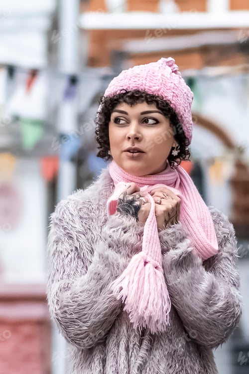 Preview: Portrait of a stylish young woman in pastel-colored warm clothes outdoors in the city in winter