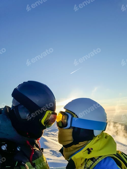 Preview: clovers couples skier and snowboarder on the sunset above winter mountains