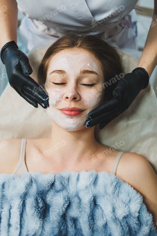 Preview: Medicine and cosmetology. The hands of a beautician in black gloves are massaging the face