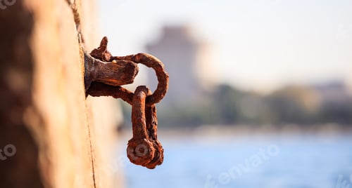 Preview: Rusty bollard waits at quay for a boat to be tied. Blurred background, close up, details, banner