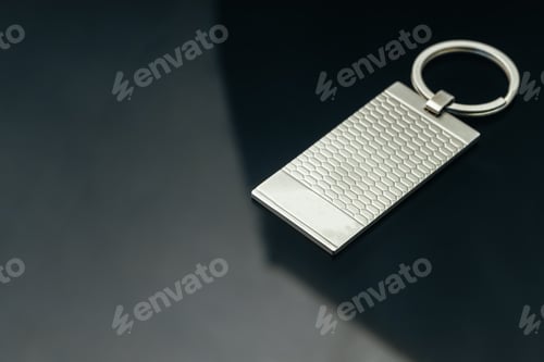 Preview: Stylish masculine metal key charm on black glass background
