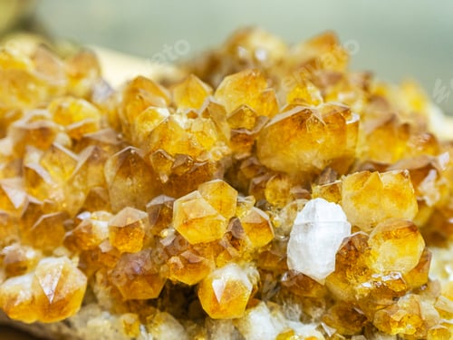 Preview: Close-up of clasters of yellow quartz crystals background. Texture of quartz crystals.