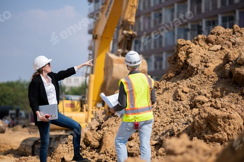 Preview: Construction Manager and engineer working construction site blueprint and laptop for survey inspecti