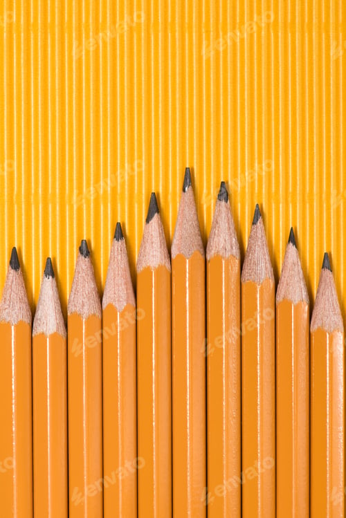 Preview: top view of graphite pencils placed in row on yellow