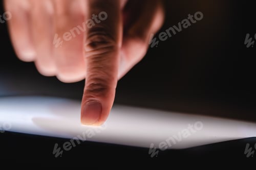 Preview: Hand or finger pointing or touching a mobile phone or tablet screen, concept of social media